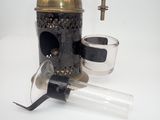 an old fashioned coffee grinder with a glass of water on a white surface