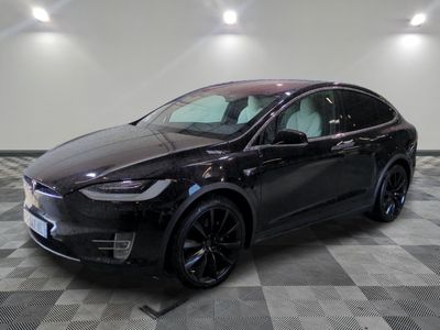 La Tesla Model X noire est garée dans une grande pièce.