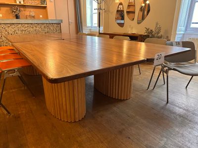 a large wooden table with chairs in a room