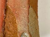 a close up of a vase on a white surface