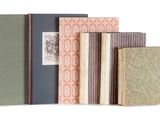 plusieurs livres sont alignés sur une surface blanche