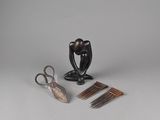 une paire de ciseaux, des peignes et une sculpture posée sur une table