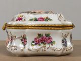 a white and gold box with pink flowers on it