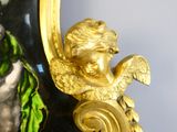 a gold statue of an angel on a black vase