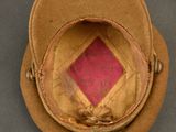 brown hat with a pink diamond on top of it on a gray surface