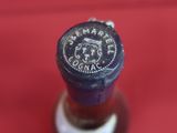 a close up of a bottle of wine on a red surface