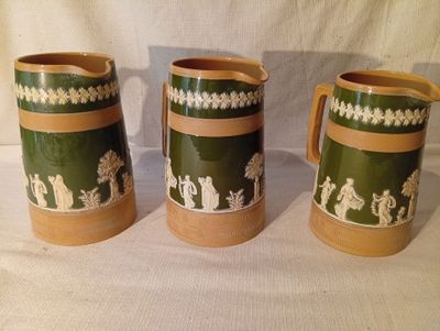 trois tasses vertes et marron posées sur une table blanche