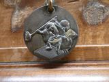 a metal medallion with a baseball player on it