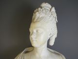 a white statue of a woman with a flower in her hair