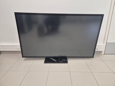 a large flat screen tv sitting on top of a tiled floor