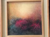 painting of a field of flowers in a wooden frame on a brick wall