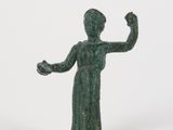 une petite statue représentant une femme la main levée