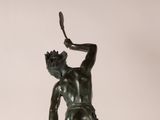 statue of a man holding a tennis racquet in his right hand