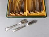 silverware in a green box with forks and spoons on a table