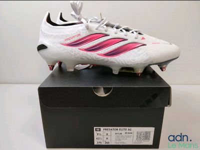 La chaussure de foot est posée sur une boîte, sur une table.