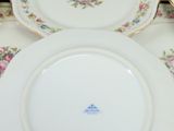 three plates with flowers on them sitting on a table