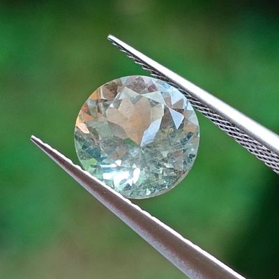 a close up of a diamond being held by a pair of pliers