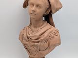 an image of a clay bust of a woman with a hat on
