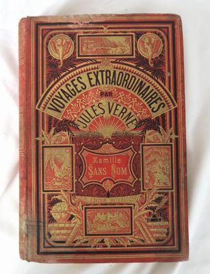 un vieux livre posé sur une surface blanche, avec une couverture rouge