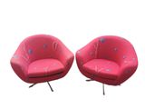 une paire de chaises roses ornées de fleurs bleues sur fond blanc