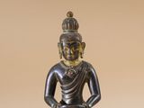 statue d'un Bouddha assis en position du lotus sur un fond beige