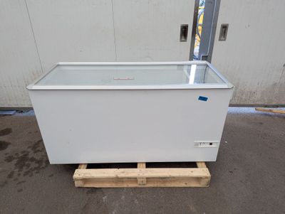 a white chest freezer sitting on a pallet in front of a building