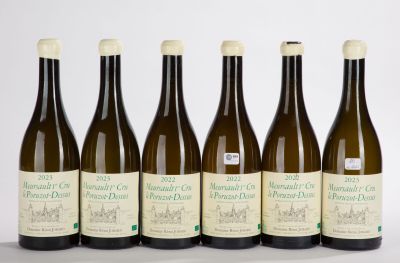 six bottles of wine are lined up on a white surface