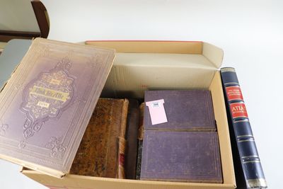 une boîte remplie de livres et un stylo posés sur une table
