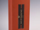 an orange box with a black label on it sitting on a white surface