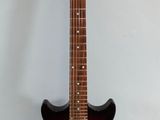 an electric guitar is sitting on a stand against a white wall