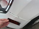 a hand that is holding a sticker on the side of a car