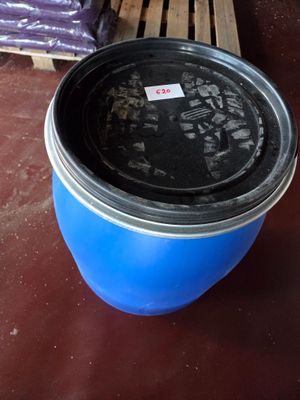 a blue bucket sitting on a pallet next to a pallet