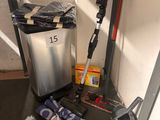 a trash can, broom, mop, and other cleaning supplies on the floor