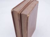 three brown books stacked on top of each other on a white surface