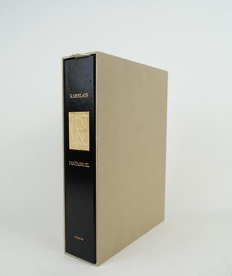 un vieux livre à la couverture noire posé sur une surface blanche