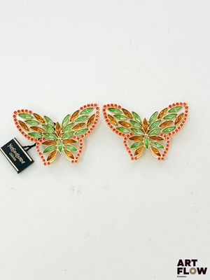 une paire de boucles d'oreilles colorées en forme de papillon sur un fond blanc