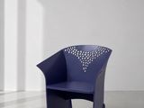 une image représentant une chaise bleue dans une pièce aux murs blancs