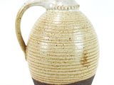 a brown and white vase with a handle on a white background