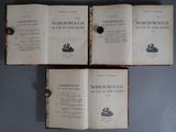 trois livres ouverts posés sur une table l'un à côté de l'autre
