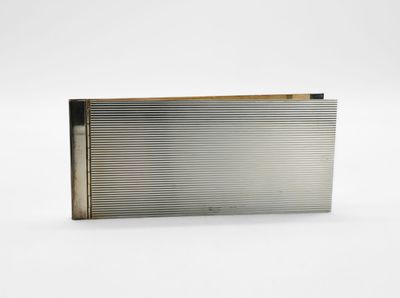 un étui à cigarettes en argent posé sur une surface blanche
