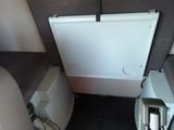 a white toilet in a small room with a door open