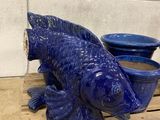 a blue fish statue sitting on a pallet next to a blue bowl