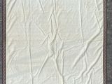 une photo d'un tapis blanc et marron avec une bordure marron