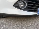 a close up of a white car with a blue license plate on it