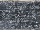 un tableau noir accroché au mur sur lequel sont écrites des inscriptions