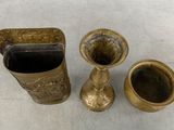 three brass vases sitting next to each other on a table