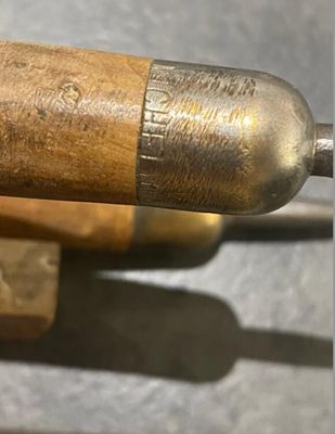 a close up of a metal object with a wooden handle