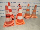 several orange and white traffic cones sitting on top of a cement floor