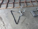 a metal triangle on the ground next to a pair of scissors