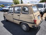 a small beige car parked in a parking lot